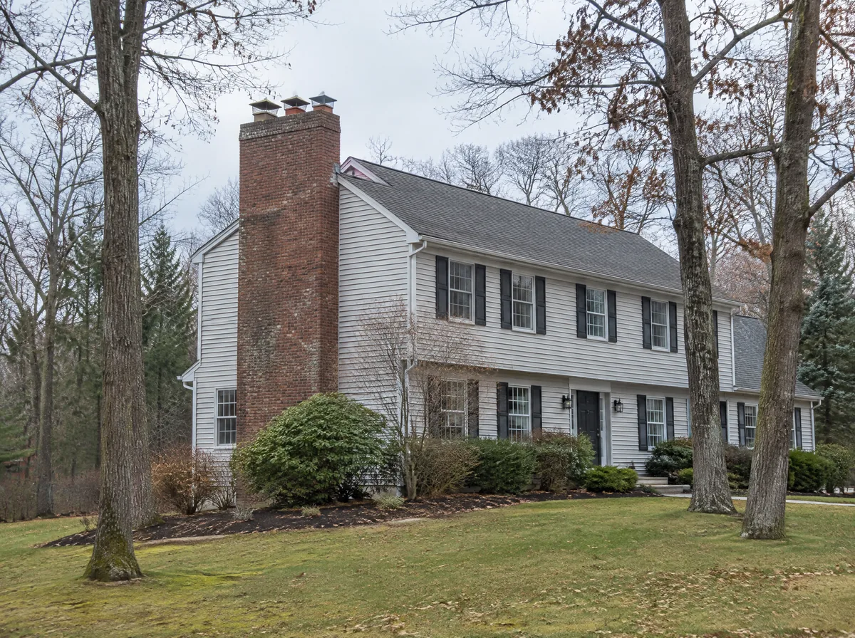 Wide brick chimney with multiple flues on a large suburban house